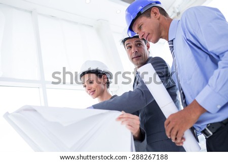 Businessman explaining a blueprint to his colleagues in the office