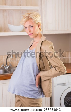 Portrait of a blonde pregnancy in the kitchen