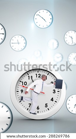 Businessman running with briefcase against digitally generated floating clock pattern