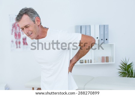 Suffering patient touching his back in medical office