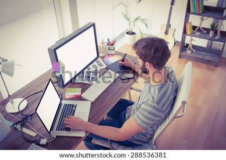 Casual young businessman using computers in office