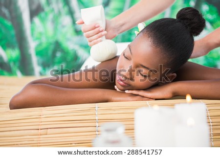 Pretty woman enjoying a herbal compress massage at the health spa