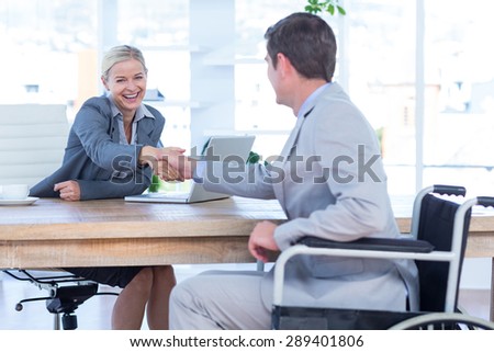 Businesswoman interviewing disabled job candidate in an office