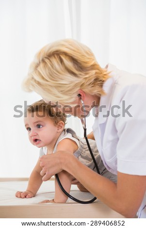 Blonde doctor with stethoscope and child in the medical office