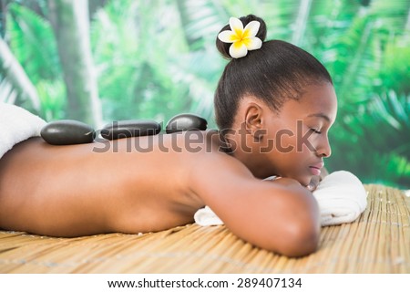 Pretty woman enjoying a hot stone massage at the health spa