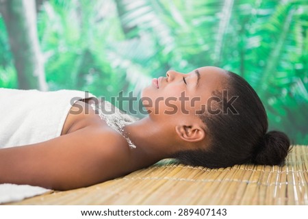 Pretty woman lying on massage table with salt scrub on the chest