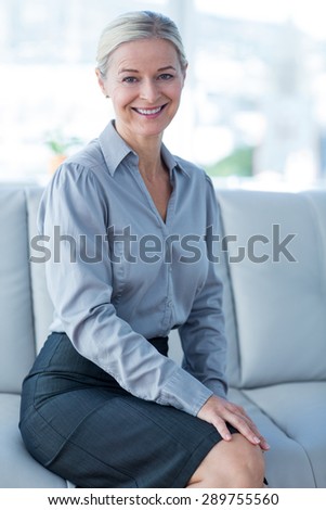 Happy businesswoman sitting on couch in living room