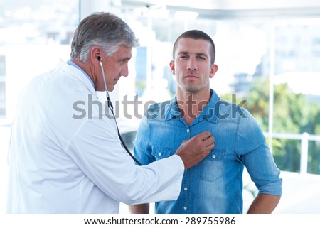 Doctor auscultating his patients chest in medical office
