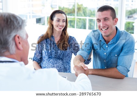 Doctor greeting future parents in medical office