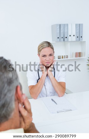 Doctor examining patient with neck ache in medical office