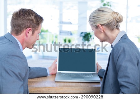 Business people watching laptop in an office