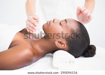 Pretty woman enjoying a reiki technique at the health spa