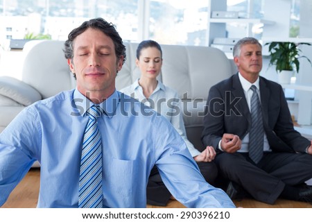 Business people practicing yoga in living room