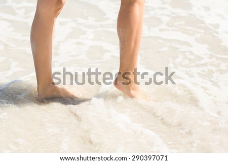 Close up view of woman foot on water at the beach