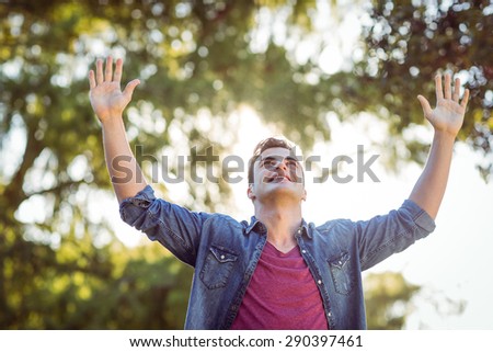 Handsome arms raised hipster on a sunny day
