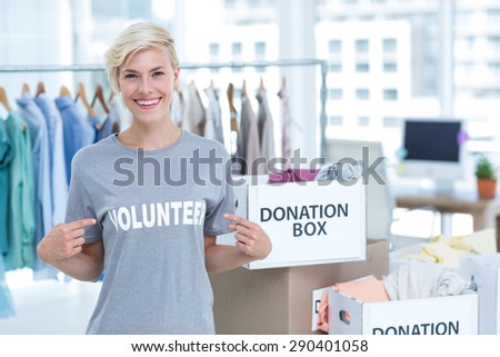 Portrait of happy female volunteer pointing to herself