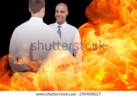 Businessman holding knife behind his back against black