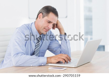 Frustrated businessman working with his computer in his office