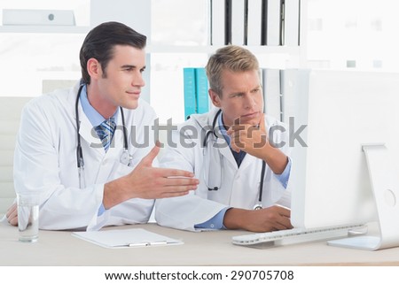 Concentrated doctors working with computer in medical office