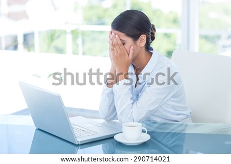 Worried businessman with head in hands in an office
