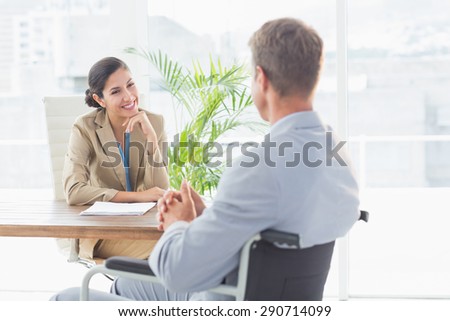 Smiling businesswoman interviewing disabled candidate in an office
