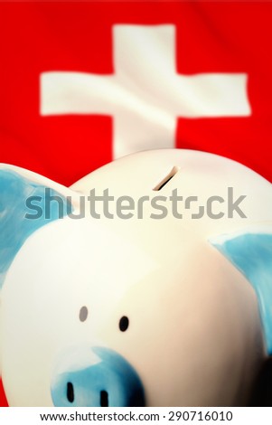 Piggy bank against digitally generated swiss national flag