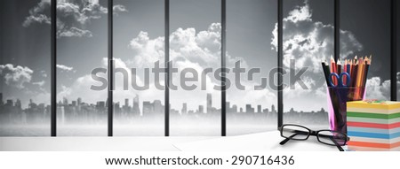desk against room with large window looking on city skyline