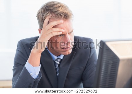 Businessman with his hand on his forehead in his office