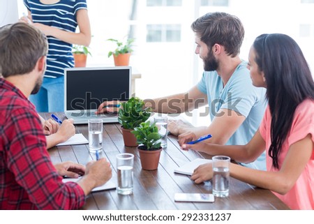 Group of young business people using laptop in office