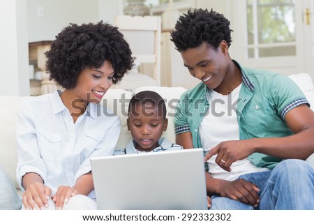 Happy family on the couch with laptop at home in the living room
