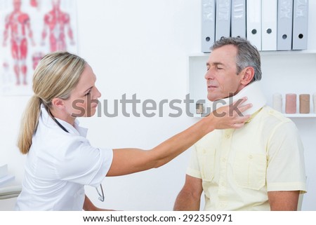 Doctor talking to patient wearing neck brace in medical office