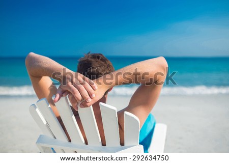 Man relaxing on deck chair at the beach on a sunny day