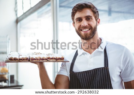 happy server holding pastry at the backery