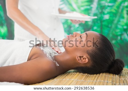 Side view of a pretty woman enjoying a salt scrub massage on the chest