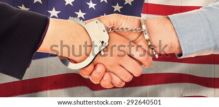 Business people in handcuffs shaking hands against pale grey wooden planks