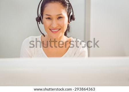 Portrait of a young call centre representative using headset in office