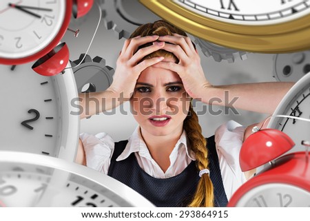 Stressed businesswoman with hands on head against grey vignette