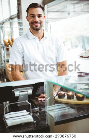 Smiling worker posing behind the counter at the bakery