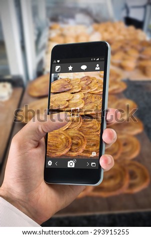 hand holding smartphone against french pastry in a palm shape on counter