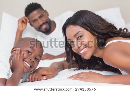 Happy family on the bed at home in bedroom
