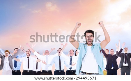 Happy casual man cheering at camera against desert landscape
