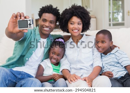 Happy family taking a selfie on the couch at home in the living room