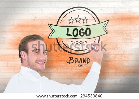 Cheerful businessman writing with marker against white wall