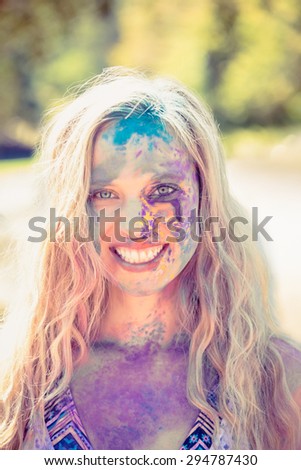 Young woman having fun with powder paint on a sunny day