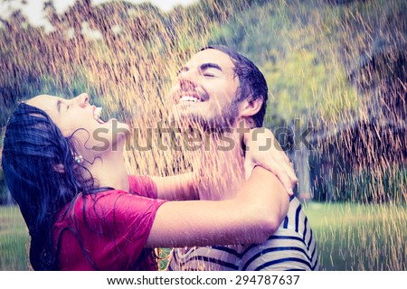 Cute couple hugging under the rain in the park