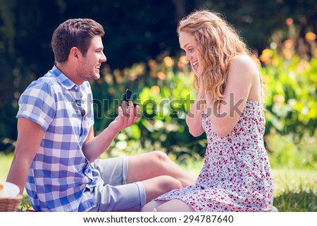 Handsome man doing marriage proposal to his girlfriend on a sunny day