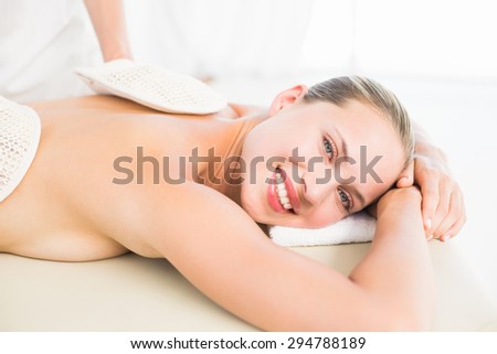 Peaceful blonde enjoying an exfoliating back massage in the health spa