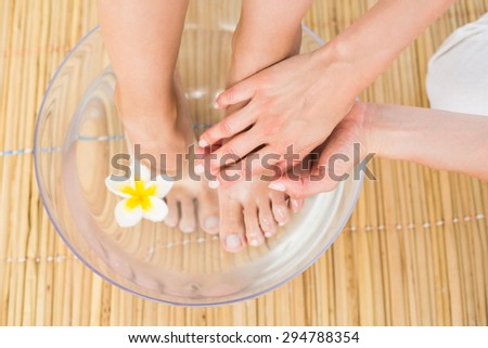 woman washing her feet in a bowl of flower at the spa institute