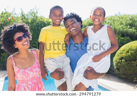 Happy family smiling at camera in the garden at home