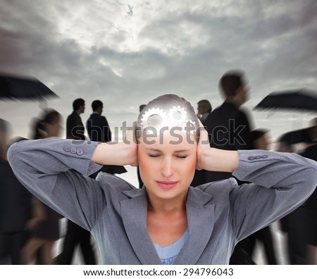 Close up of annoyed tradeswoman covering her ears against grey sky